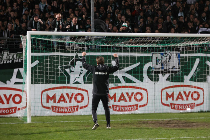 Trainer Lukas Pfeiffer (VfB Lübeck) feiert vor der Pappelkurve