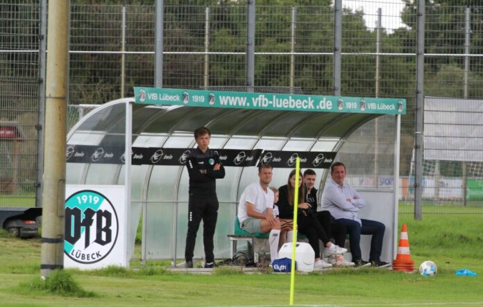 Tommy Grupe, Marius Hauptmann und Sebastian Harms schauen beim Training des VfB Lübeck zu