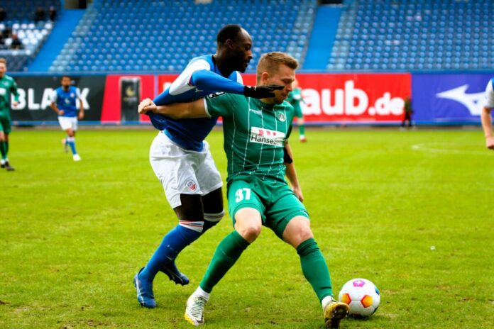 Janek Sternberg (VfB Lübeck) im Duell mit Christian Kinsombi (F.C. Hansa Rostock)